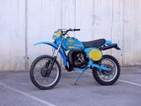 a blue and yellow dirt bike parked in a parking lot