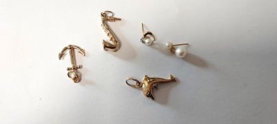three pairs of earrings and a hook on a white surface
