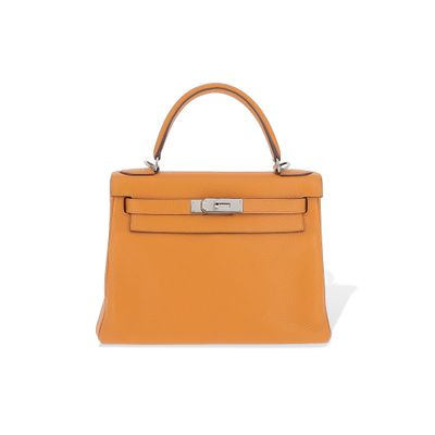un petit sac à main en cuir orange sur fond blanc