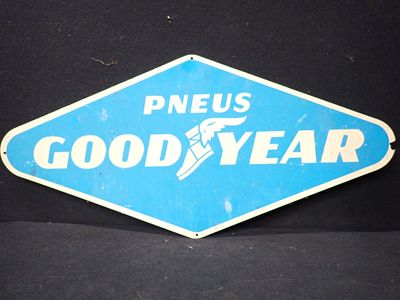 un panneau bleu et blanc sur lequel est inscrit « Pneus Good Year »