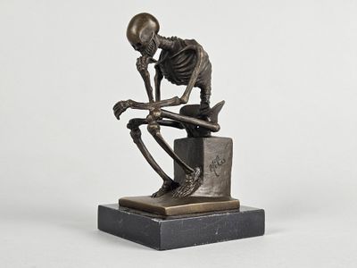 statue représentant un squelette assis sur une boîte sur laquelle repose un crâne