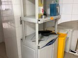 a small kitchen with a washing machine and a yellow trash can