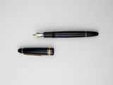 a pen and a ballpoint pen laying on top of each other