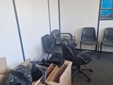 a pile of boxes and chairs in the corner of a room