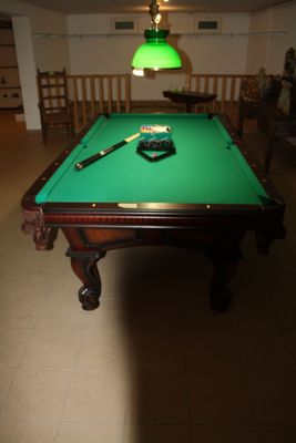 a pool table with a green cloth on it in a room