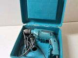 an electric drill in a blue case on a white surface