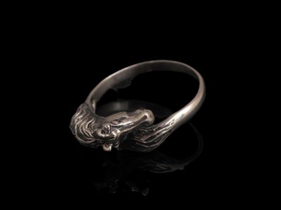 gros plan d'une bague en argent sur une surface noire