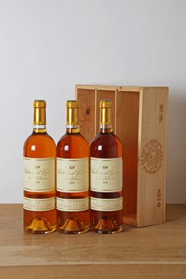 three bottles of wine in front of a wooden box on a table
