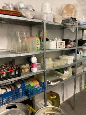 many shelves of food in the kitchen with pots and pans on them