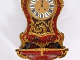 une horloge rouge et dorée accrochée au mur