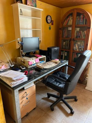 a desk with a computer and a chair in a room