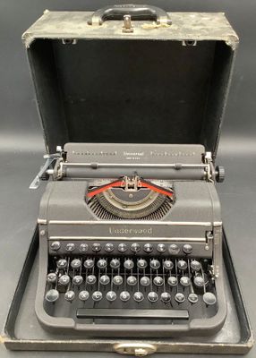 an old typewriter with a case on it sitting on a table