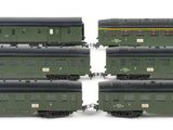 four green train cars sitting next to each other on a white surface