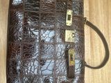 an image of a brown purse sitting on top of a wooden floor