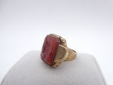 an image of a gold ring with a red stone in it