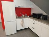 une cuisine avec un réfrigérateur blanc et un mur rouge