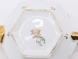 a white plate with a gold trim and a flower on it