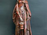 wooden statue of a woman with a cat and a green apple
