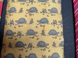 a yellow tie with a pattern of turtles on it