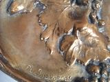 a silver plate with a picture of a woman and a horse on it