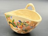 a small bowl with a handle on a table