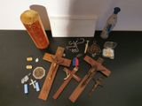 a cross, a bottle of beer, and other religious items on a table