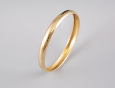 a gold wedding ring on a white background