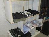 a white shelf with clothes on it in a room