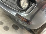 a close up of a car ' s front bumper with a sticker on it