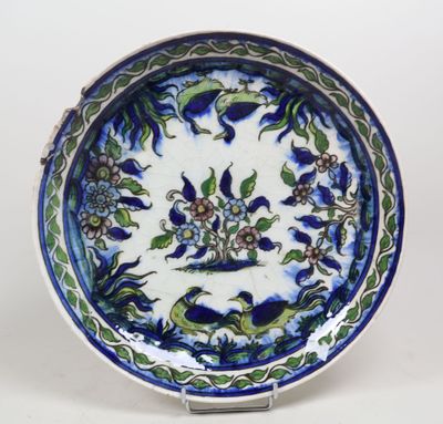 une assiette bleue et blanche décorée de fleurs et de feuilles