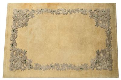 une image représentant un tapis beige orné d'une bordure de fleurs et de feuilles