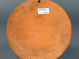 a small orange plate with a tag on it