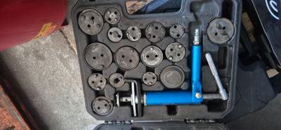 un jeu d'outils rangé dans une boîte à outils posée par terre