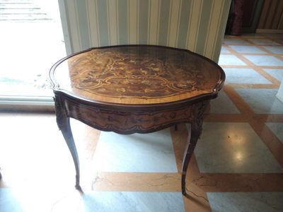 une petite table avec un plateau en verre sur un sol en marbre