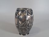 a silver vase that is sitting on a table