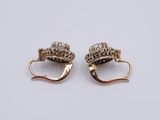 two pairs of gold and diamond earrings on a white surface
