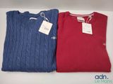 two red and blue sweaters on a table with a price tag