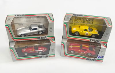 trois boîtes contenant des petites voitures, posées sur une surface blanche