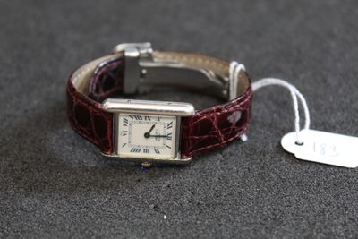 une montre posée sur une table, à laquelle est attachée une étiquette