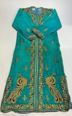 a green dress with gold and blue embroiderys on it