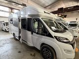 un camping-car blanc garé à l'intérieur d'un bâtiment