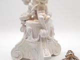 a small statue of a boy sitting on a pedestal