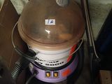 a bucket with a brown lid sitting on top of a machine