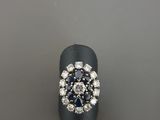 une photo d'une bague sertie d'un diamant et d'un saphir posée sur une table