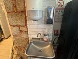 un lavabo dans un coin de la salle de bains, avec une serviette accrochée au mur