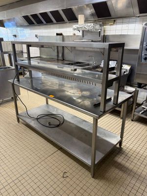 une grande cuisine avec de nombreux plans de travail en inox