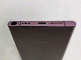 the back of a purple samsung phone sitting on top of a table
