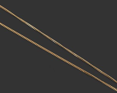 une paire de chaînes en or avec un pendentif en diamant sur fond noir