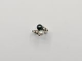 a black pearl and diamond ring on a white surface