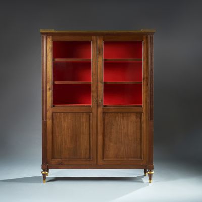 une bibliothèque ancienne en acajou, avec des portes en verre rouge et des pieds en laiton